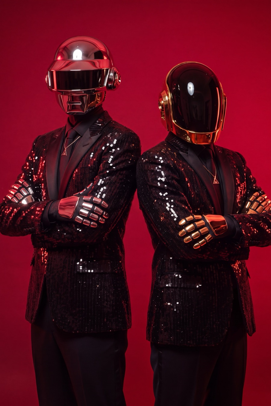 Studio portrait of the two robots in sequin jackets on red